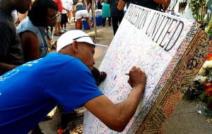 Mark Lawrence of Charleston is one of hundreds who signed a "Charleston United" canvas outside Emanuel AME Church in Charleston over the weekend.