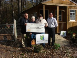 Jackson EMC Foundation board member Jim Puckett (far left) and Jackson EMC District Manager Randy Dellinger (far right) present a $7,500 Foundation grant check to Adventure Bags President/CEO Debi Gori and Executive Board Member Joe Riehle.