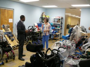 FODAC staffer Pam Holley shows DeKalb Interim CEO Lee May the inventory of pediatric wheelchairs, many collected through equipment drives like the one being held by EACU.