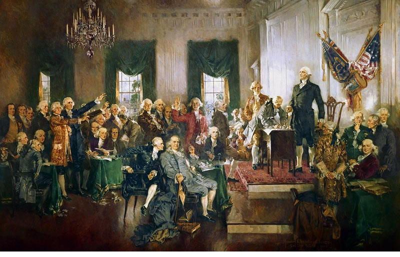 Scene at the Signing of the Constitution of the United States, a painting by Howard Chandler Christy. In the center is Benjamin Franklin (seated). Alexander Hamilton, also seated in blue, appears to be whispering in his ear. George Washington is standing by the desk. To identify other signers, click here.