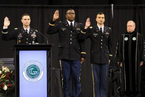 Maj. Andrew Banister administers the oath of office to newly commissioned U.S. Army 2nd Lieutenants Adrian Brown and Roberto Cerqueira, as GGC President Stas Preczewski looks on.